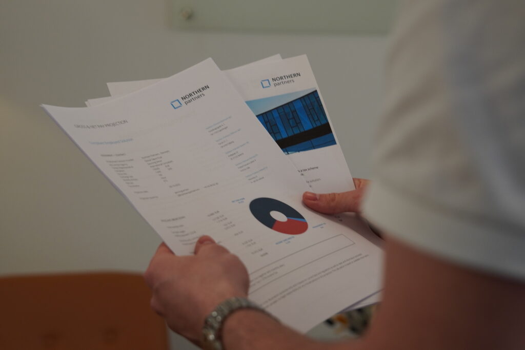 Person reviewing payroll and contract documents from Northern Partners