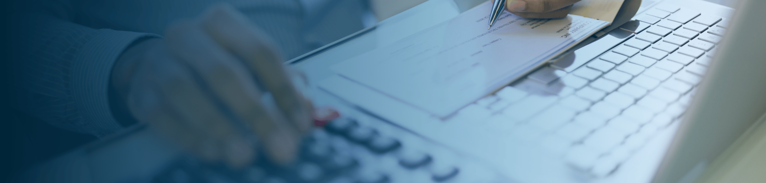 Close-up of hands managing payroll and documentation on a lapto